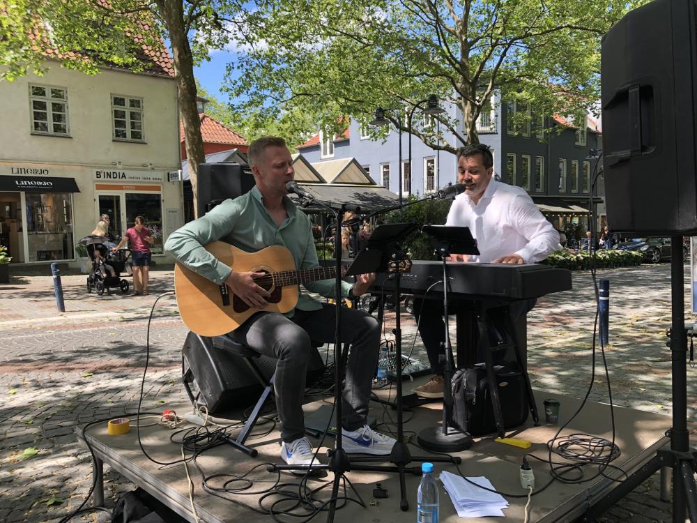 Det er den lokale musik-duo, Mikkel Sonne (tv) og Martin Jantzen, der står for fællessang på Lyngby Hovedgade.