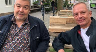 Carsten Bak (tv) og Richard Sandbæk prøvesidder Lyngby Hovedgades nye pallemøbler lavet af genbrugstræ. Ligesom fællessang er møblerne en del af kommunens og handelsforeningens fælles projekt om at skabe liv i hovedgaden, mens der arbejdes med letbanen.